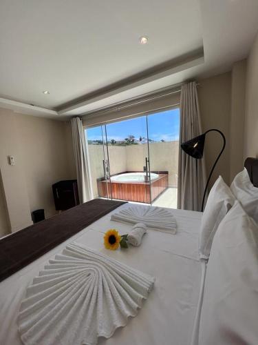 a white bed with a sunflower on top of it at Pousada Arraial Tropical in Arraial do Cabo