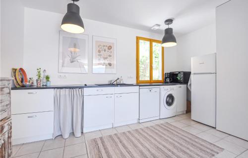 a kitchen with white cabinets and a washer and dryer at Cozy Home In Bargemon With Wifi in Bargemon