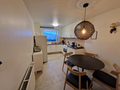 een keuken en eetkamer met een tafel en stoelen bij North Inn - Guesthouse and Cabin in Akureyri