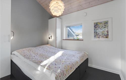 a bedroom with a bed and a window and a chandelier at Holiday Home Toftlund With A Fireplace 09 in Arrild