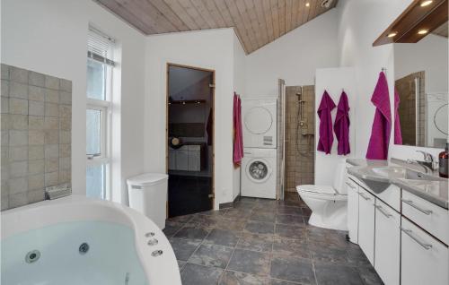 a bathroom with a tub and a toilet and a sink at Holiday Home Toftlund With A Fireplace 09 in Arrild