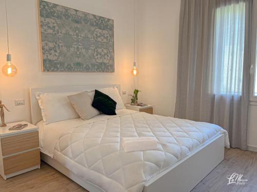 a bedroom with a large white bed and a window at La Maison Fois - Appartamento Quartucciu in Quartucciu