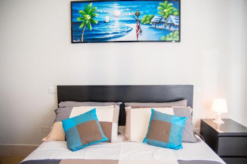 佩斯卡拉的住宿－3 SUITES Padronali 300m DAL MARE，一间卧室配有一张带蓝色和白色枕头的床