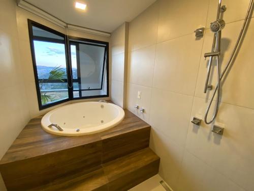La salle de bains est pourvue d'un lavabo et d'une fenêtre. dans l'établissement Carpe Diem Spa & boutique, à Campos do Jordão