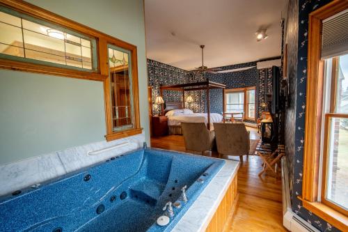 a large blue tub in a room with a bedroom at Albergo Allegria Hotel & Breakfast Restaurant in Windham