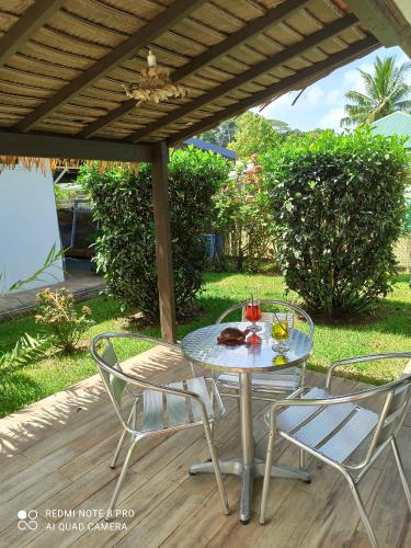 a table and two chairs under a pergola at La Maison Du Voyage in Tevaitoa