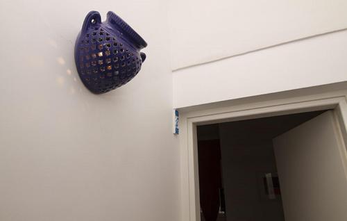 a blue basket hanging on a wall next to a doorway at La Dimora dell' Architetto in Gravina in Puglia