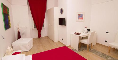 a white room with a table and a red curtain at La Dimora dell' Architetto in Gravina in Puglia