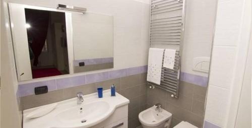 a bathroom with a sink and a mirror and a toilet at La Dimora dell' Architetto in Gravina in Puglia