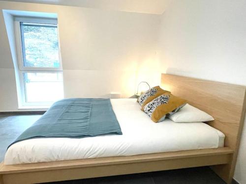 a bed with two pillows on it in a bedroom at Penthouse with Garden and Parking in Center- KPG in Luxembourg