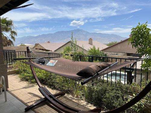 a hammock on a balcony with a view of a house at Miracle mineral water pool and spa in Desert Hot Springs