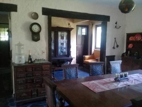 a living room with a table and a clock on the wall at El Betete-Disfrute de la Sierra de las Animas in Pan de Azúcar