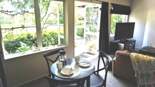 a living room with a table and chairs and a television at Maddisons Garden Guest Suite - Coatesville in Albany