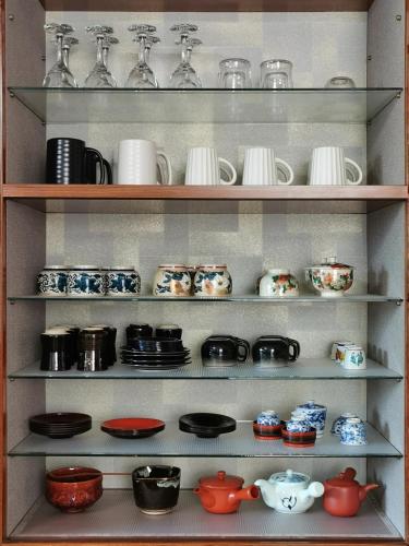 a shelf filled with plates and cups and dishes at 心遊亭Shin Yu Tei 一軒雅宿 in Kanazawa