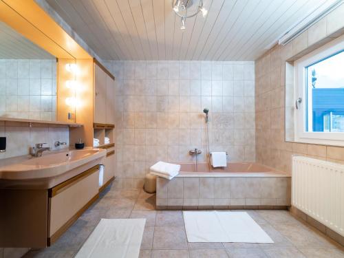 y baño con bañera y lavamanos. en Haus Andrea, en Klösterle am Arlberg