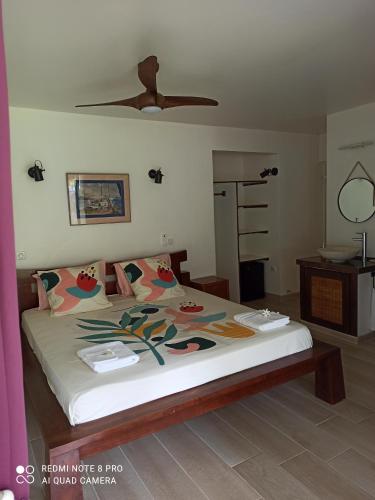 1 dormitorio con 1 cama y ventilador de techo en La Maison Du Voyage, en Tevaitoa