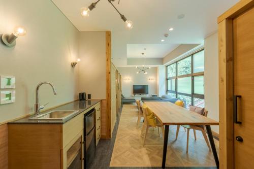a kitchen with a wooden table and a dining room at Hishino Onsen Tokiwakan in Komoro