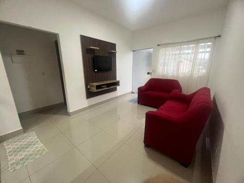 uma sala de estar com um sofá vermelho e uma televisão em Casa para temporada Caldas Novas-GO Brasil em Caldas Novas