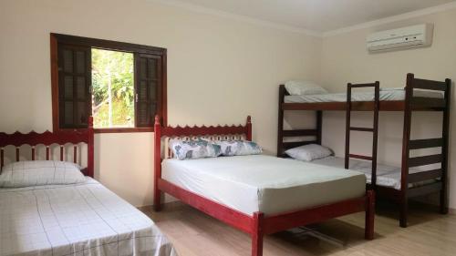 a bedroom with two bunk beds and a window at Casas Jacatirão in Ubatuba