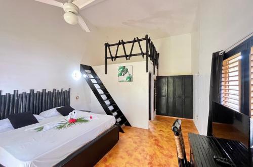 a bedroom with a bed and a spiral staircase at Hotel Rincon Rubi in Las Galeras