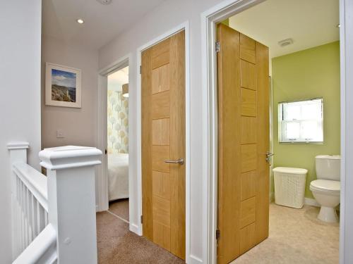 a bathroom with a toilet and a wooden door at Platform 10 in Bideford