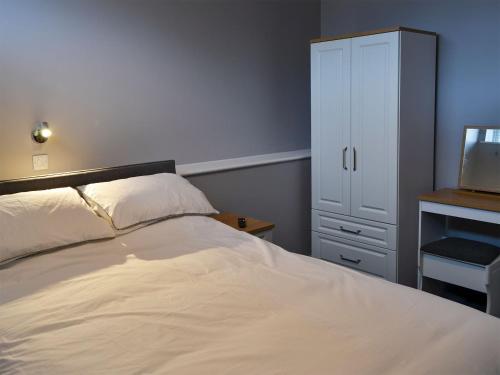 ein Schlafzimmer mit einem Bett, einer Kommode und einem TV in der Unterkunft Apartment 3 The Beach Hut - Uk31822 in Great Yarmouth