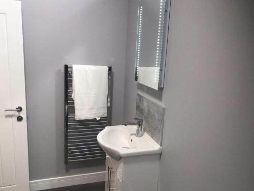 ein weißes Badezimmer mit einem Waschbecken und einem Spiegel in der Unterkunft Apartment 3 The Beach Hut - Uk31822 in Great Yarmouth