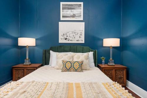 a bedroom with blue walls and a bed with two lamps at Vintage Crown in Galveston