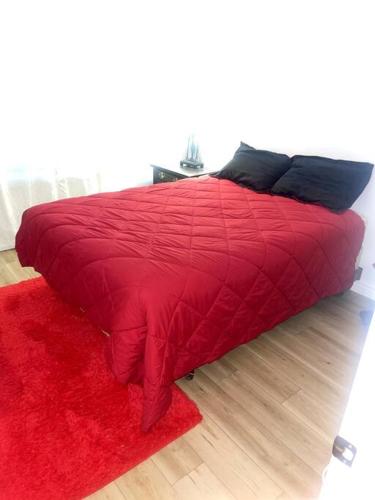 a red bed with a red blanket and a red rug at 4 Bedroom Home-Casino-State Farm Stadium only 2 Miles in Glendale