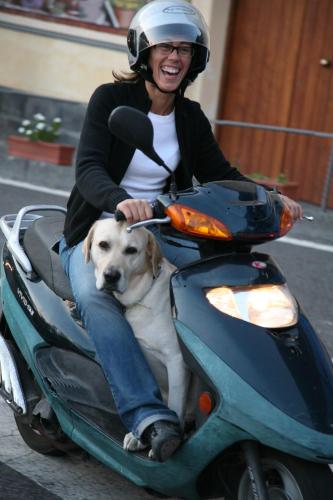 a woman riding on a scooter with a dog at Amalfi 51 con vista mare, giardino e terrazze in Conca dei Marini