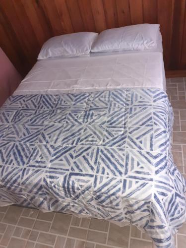 a bed with a white comforter on top of it at Sítio Bona Vita in Nova Trento