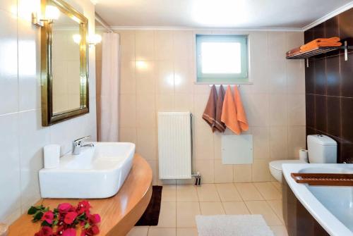 a white bathroom with a sink and a toilet at Villa Verde in Arménoi