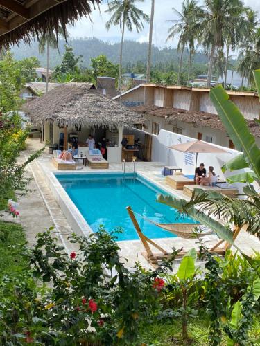 a pool at a resort with people sitting around it at Parrots Boutique Resort in San Vicente