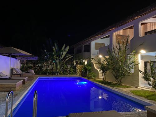 a swimming pool in a yard at night at Parrots Boutique Resort in San Vicente