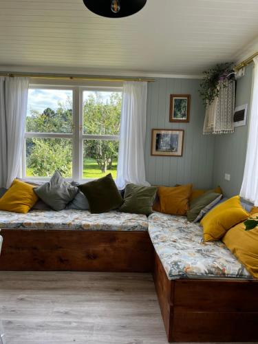 a large couch in a room with a window at Wisteria Way in Opononi