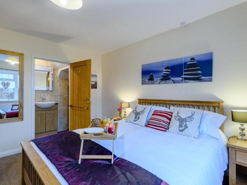 a bedroom with a large white bed and a bathroom at Pirates Lookout in Wells next the Sea