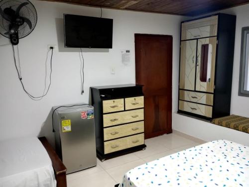 a room with a refrigerator and a tv on the wall at Hotel Bethesda in Aguachica
