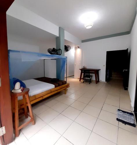 a bedroom with a bunk bed and a table at Merdeka House in Maluk