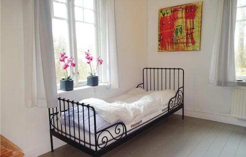 a bed in a room with two windows and flowers at 2 Bedroom Amazing Home In Markaryd in Markaryd