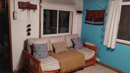 sala de estar con sofá y ventana en Cabaña Morena en Mar de las Pampas