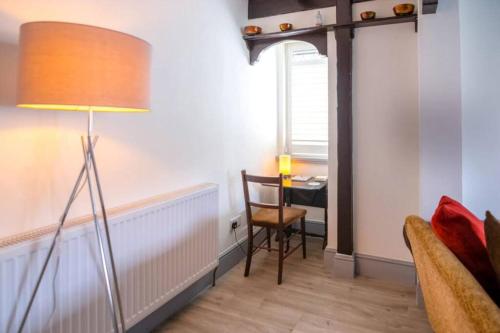 a living room with a table and a lamp at A Bright and Spacious Gem in Staines