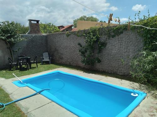 una piscina azul en un patio junto a una pared en Casa en Mendoza en Godoy Cruz