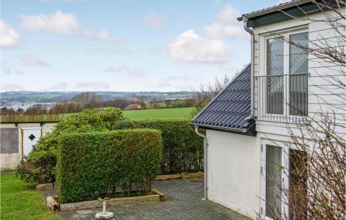 a white house with a window and a hedge at Nice Home In Erslev With Wifi in Erslev