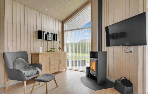 a living room with a fireplace and a chair and a television at Stunning Home In Lemvig With Wifi in Lemvig