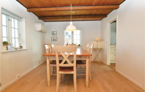 a dining room with a wooden table and chairs at Holiday Home Fanø 55 in Sønderho