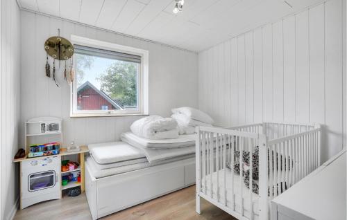 ein Kinderbett in einem weißen Zimmer mit Fenster in der Unterkunft Gorgeous Home In Glesborg With Wifi in Glesborg