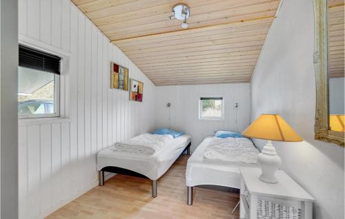 ブラーバンドにあるAmazing Home In Blvand With 5 Bedrooms, Sauna And Wifiのベッド2台、テーブル、ランプが備わる客室です。
