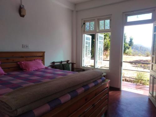 a bedroom with a bed and a large window at Forest Cyniciam Homestay in Ohiya