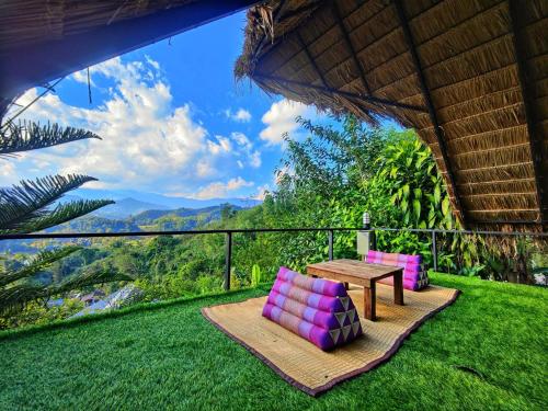 uma varanda com uma mesa e cadeiras e uma vista em Flower hill 180 em Chiang Rai