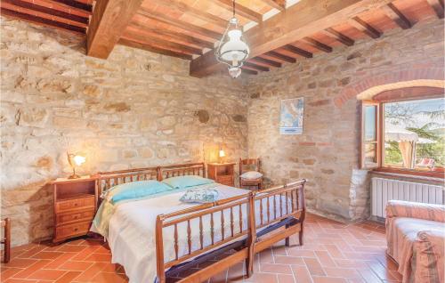a bedroom with a bed and a stone wall at Beautiful Home In Castiglion Fiorentino With Kitchen in Pergognano